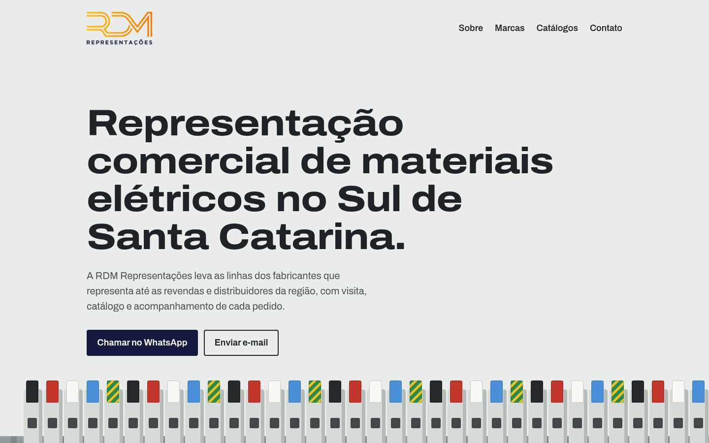 The RDM Representações site on a desktop: the company logo, a large headline about commercial representation of electrical materials in southern Santa Catarina, WhatsApp and email buttons, and a row of DIN-rail terminals in brand colours.